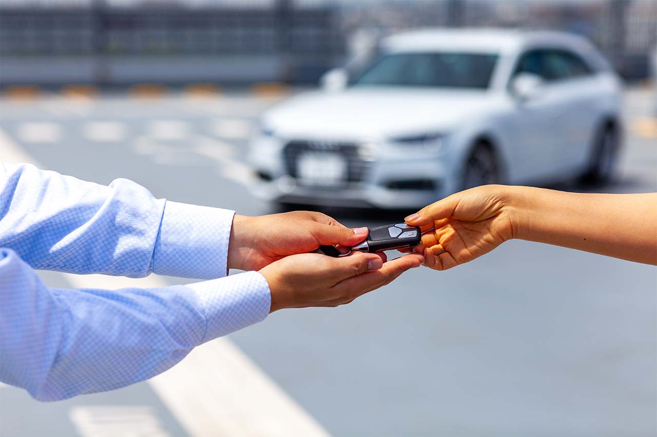 社員から愛車のキーを受け取るお客様